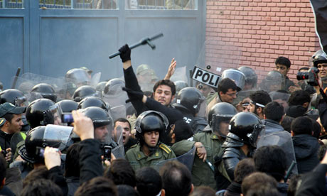 Iranian riot police stand guard as protesters gather outside the British embassy in Tehran 