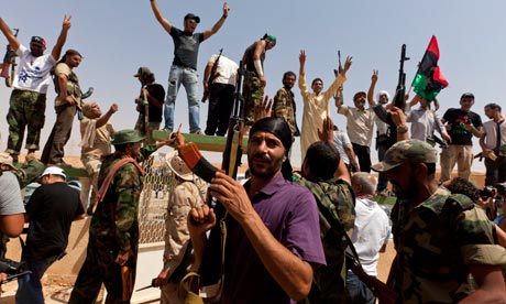 Libyan NTC fighters celebrate at a checkpoint between Tarhouna and Bani Walid