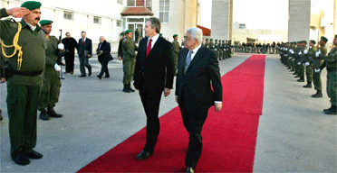 Tony Blair and Palestinian president Mahmoud Abbas walk past an honour guard in Ramallah