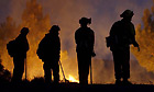 Firefighters are silhouetted