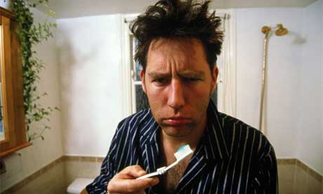 Man with hangover brushes teeth