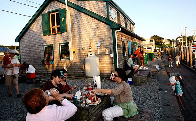 People eat behind Larson's Seafood in Menemsha, Massachusetts on the island of Martha's Vineyard.