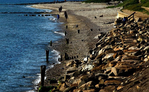 Visitors take a stroll on the beach in Oak Bluffs, Massachusetts on the island of Martha's Vineyard