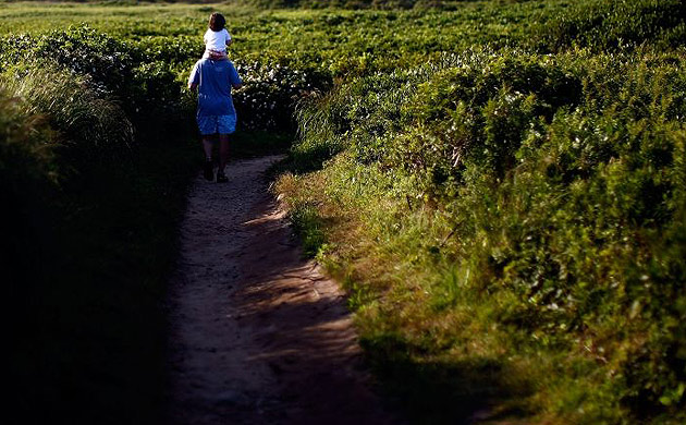 James Cruzen carries his daughter on his shoulders while leaving the beach at Gay Head in Aquinnah, Massachusetts on the island of Martha's Vineyard.