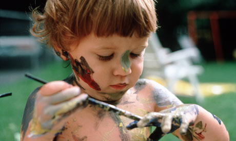 A litte child plays with paint