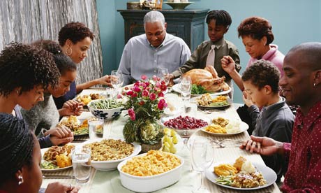 Family saying grace at Thanksgiving