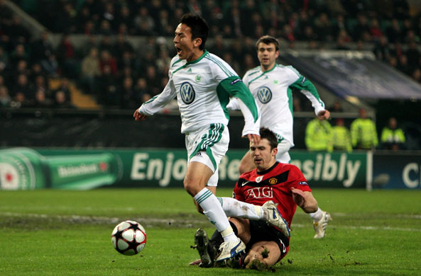 United & Chelsea: Makoto Hasebe of Wolfsburg is brought down by United's Michael Carrick