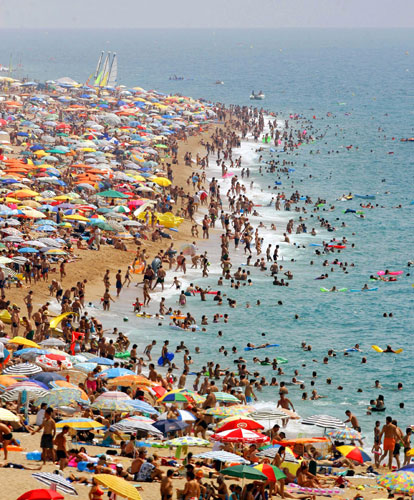 Costa Brava or Bahamas?: Crowds in the Mediterranean sea on Calella's beach, the Costa Brava, Spain.