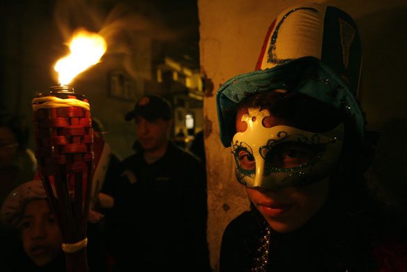 Carnival: A man in a mask participates in carnival celebrations in Ecuador