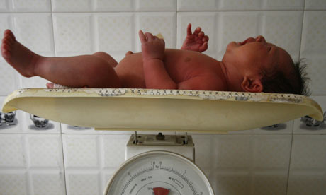 A baby cries while being weighed
