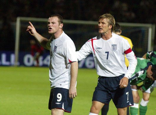 Hot headed Rooney: Beckham attempts to console Rooney after he is shown a yellow card 