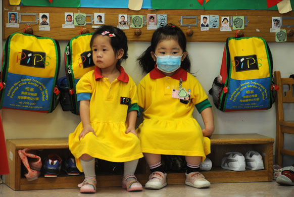 Swine flu pandemic: A girl wearing a mask at a kindergarten in Hong Kong