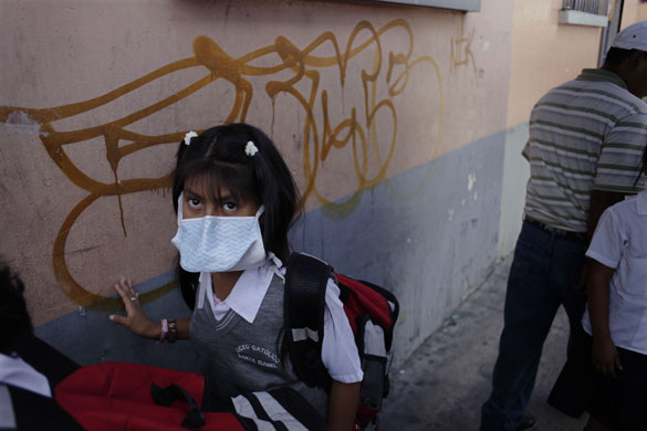 Swine flu pandemic: A girl wearing a face mask, leaves school in Guatemala City