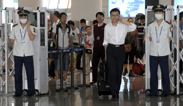 Swine flu pandemic: Two airport employees wear masks at Beijing International Airport