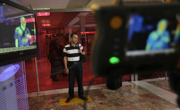 Swine flu pandemic: A man stands in front of thermal camera at the airport in Mexico City