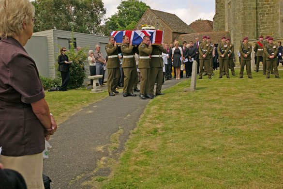 Isolation: Army Pallbearers carry a solider's coffin in a rural churchyard