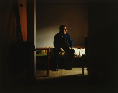 Isolation: A man sits alone on a bed