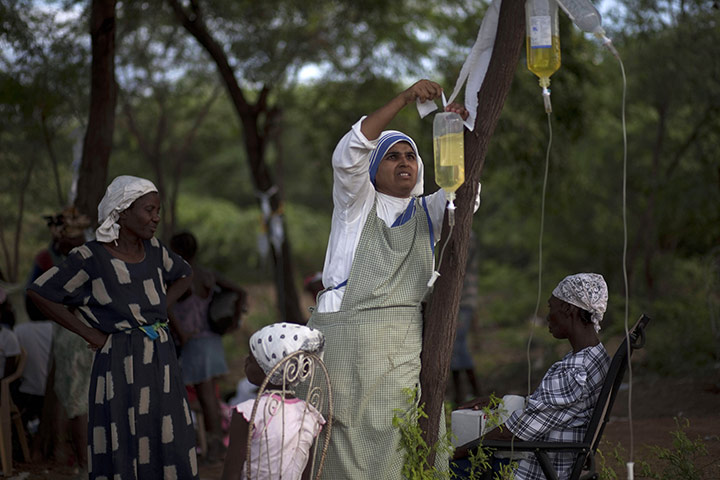 Cholera in Haiti: A nun hangs a serum bag on a tree for patients 