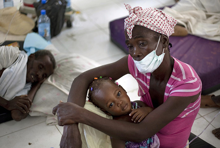 Cholera in Haiti: A woman holds her young daughter while receiving medical attention
