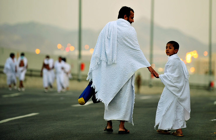 Hajj, Saudi Araba: A Muslim pilgrim walks with his son 