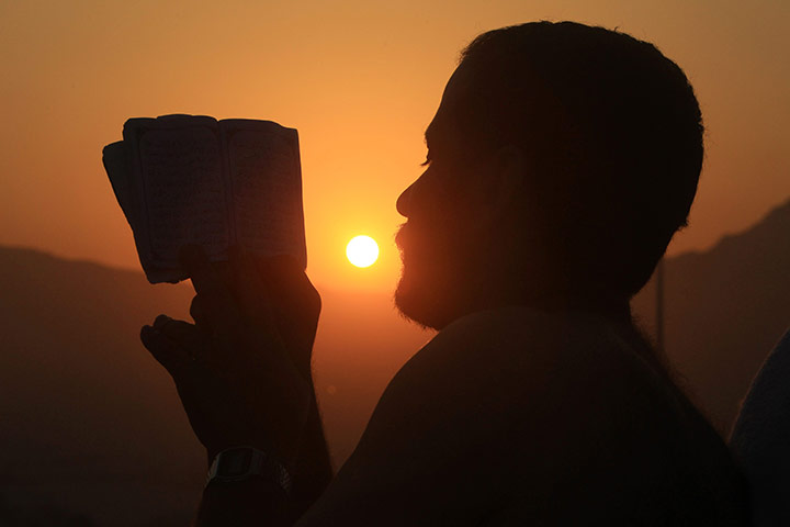 Hajj in Mecca: Muslim pilgrim reads the Koran on Mount Mercy on the plains of Arafat