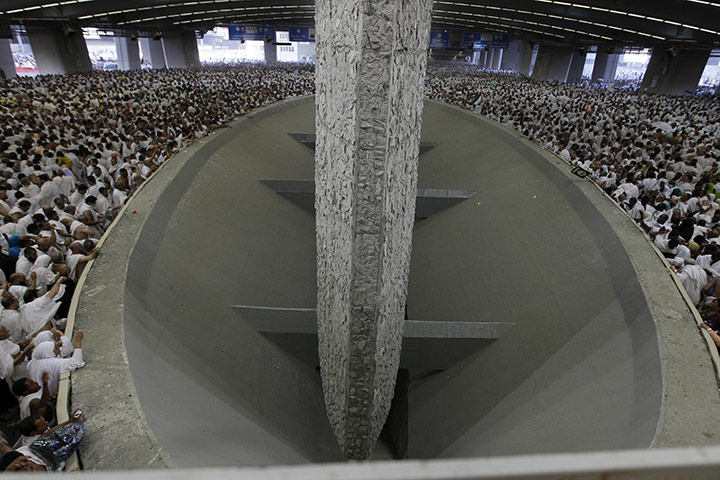 Hajj Pilgrimage: Muslim pilgrims cast stones at a pillar, symbolizing the stoning of Satan