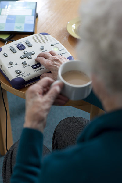 75th Anniversary of RNIB Talking Books: An elderly woman operates her Talking Book player