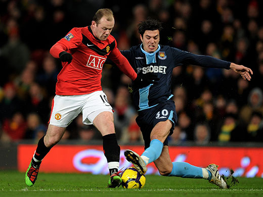 Wednesday football: West Ham's James Tomkins tackles Man United's Wayne Rooney 