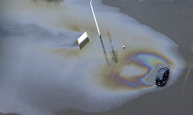 24 hours in pictures: An oil slick spreads from a car in a flooded parking lot