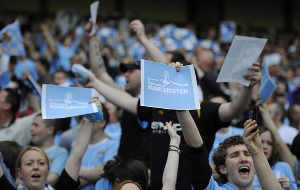 City v United: City fans with signs of the infamous Welcome to Manchester Tevez poster