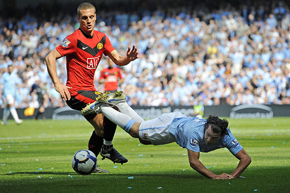 City v United: Tevez goes down in the box under the challenge of Vidic