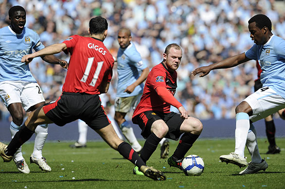 City v United: Rooney slides the ball past Onoura into the path of Giggs