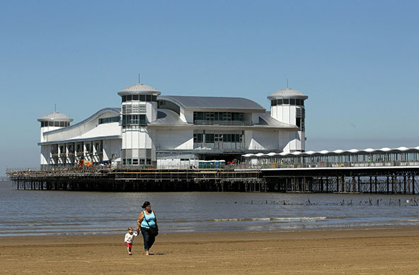 Grand Pier: People walk on the beach in front of the rebuilt Grand Pier