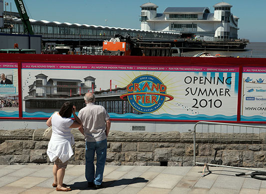 Grand Pier: People stop to read a bill board