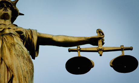 A statue holding the scales of justice on top of the Old Bailey
