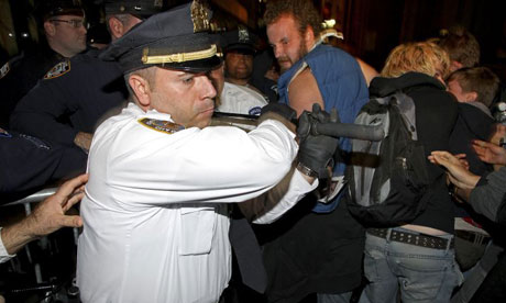 A senior New York police officer swings his baton at Occupy Wall Street protesters