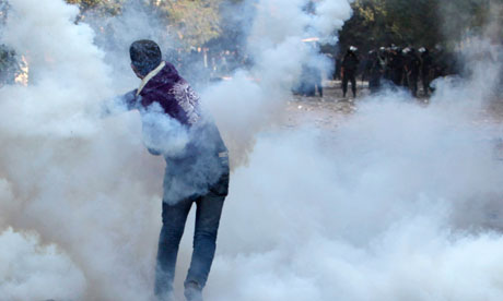 An Egyptian anti-government protester throws a teargas canister back at riot police in Tahrir Square
