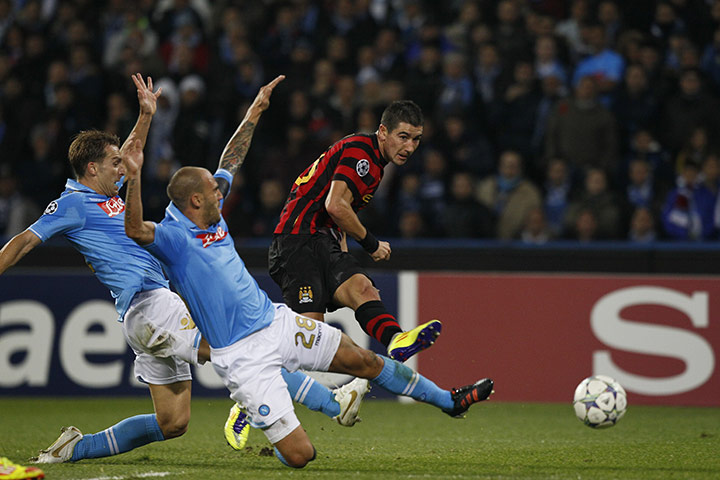 Tuesday Champions League: Edin Dzeko fires a shot past Napoli's Salvatore Aronica and Paolo Cannavaro