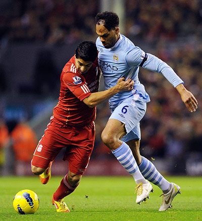 Sunday football: Luis Suarez is challenged by Joleon Lescott