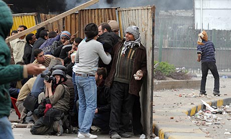 Foreign journalists and Egyptian anti-goverment protesters take cover during clashes