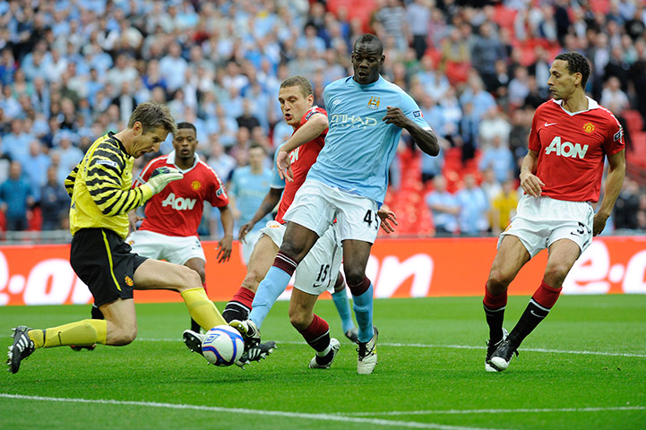 Man City v Man Utd: Van der Saar takes a clatter on the ankle as he saves from Balotelli
