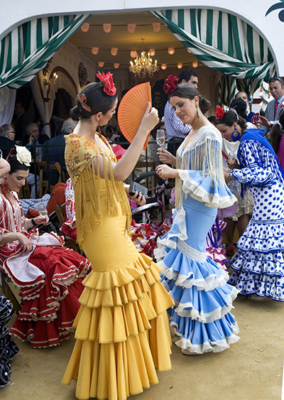 Feria de Seville: Women wearing traditional dresses dance at thee fair