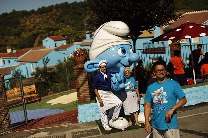 Juzcar: Blue Town: People stand next to a smurf decorative statue