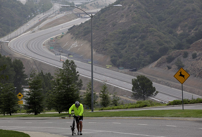 Carmageddon: A man walks his bike as a 10-mile stretch of Interstate 405 is shut down