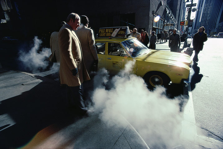 Yellow taxicabs: 1980: Steam rises from the sidewalk as businessmen get a taxicab