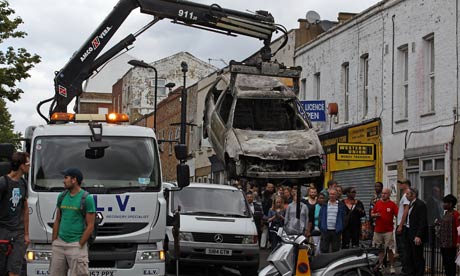 xRiots: Burnt out cars are removed from a residential street in Hackney