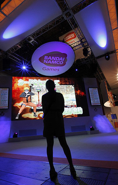 Tokyo Game Show: A woman looks at Bandai Namco's promotional video