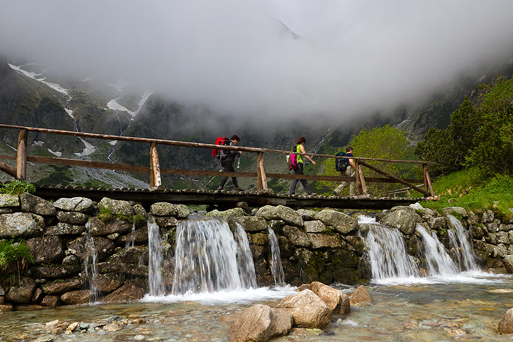 slovakia: Tourists crossing a stream.