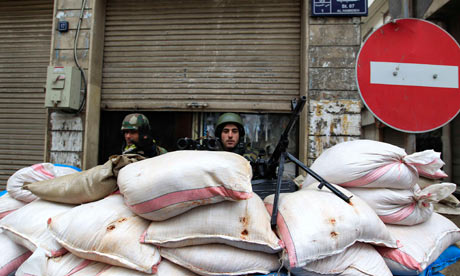 Syrian soldiers man a checkpoint in Homs