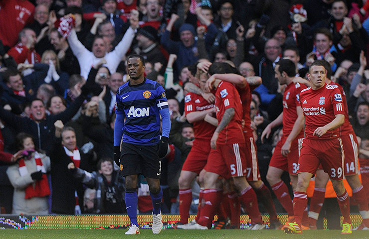 Liverpool v Man Utd: A dejected Patrice Evra as Liverpool celebrate their 2nd goal